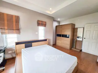 Spacious bedroom with modern wooden furniture and natural light