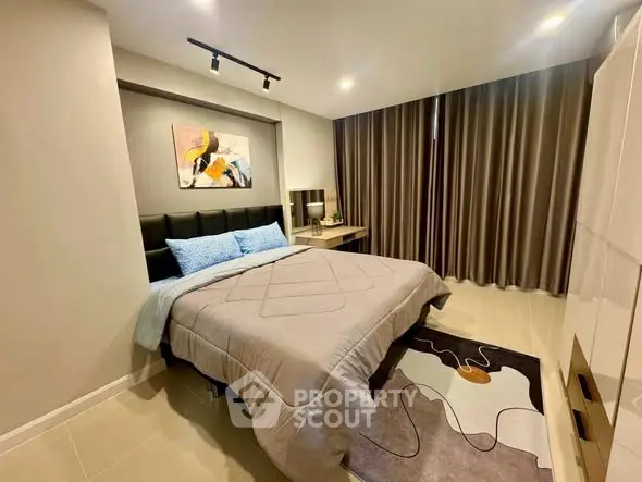 Modern bedroom with stylish decor and cozy ambiance, featuring a comfortable bed and elegant lighting.