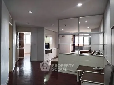 Spacious living room with modern decor and open layout, featuring hardwood floors and ample natural light.