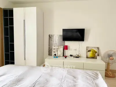 Modern bedroom with sleek furniture and wall-mounted TV