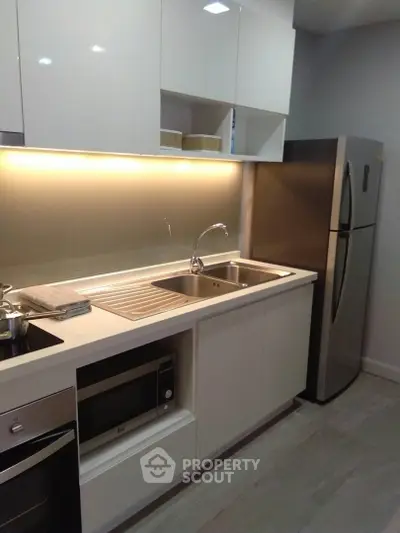 Modern kitchen with sleek cabinetry, stainless steel appliances, and under-cabinet lighting.