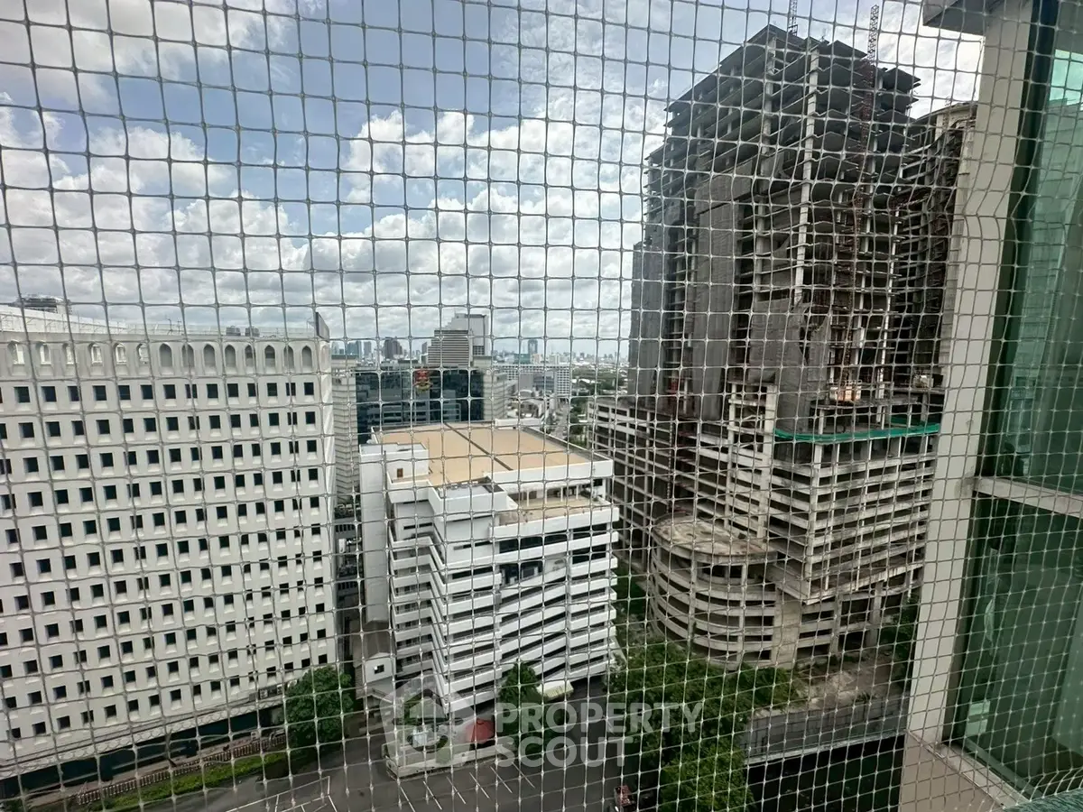 Urban cityscape view from high-rise building with construction site and skyline.