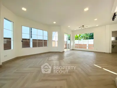 Spacious and bright living room with large windows and modern flooring