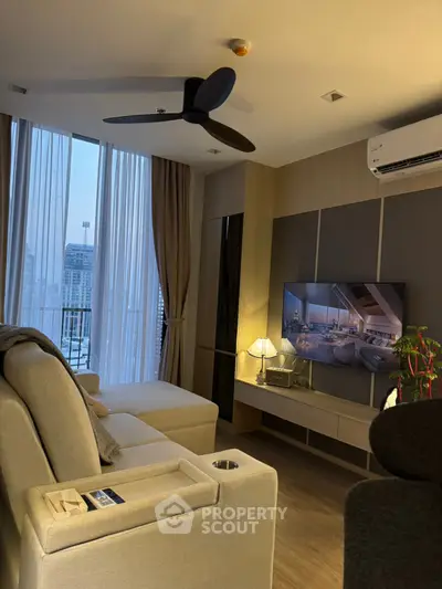 Modern living room with stylish decor and city view from large windows.