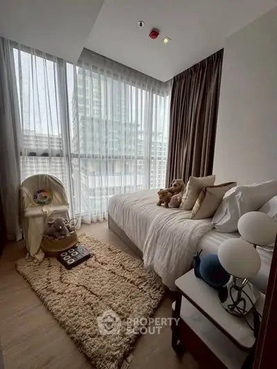 Cozy bedroom with plush decor and large windows offering city views.