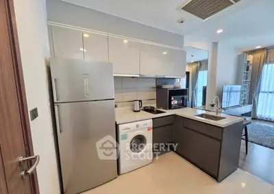 Modern kitchen with appliances including fridge, washing machine, and oven in stylish apartment.