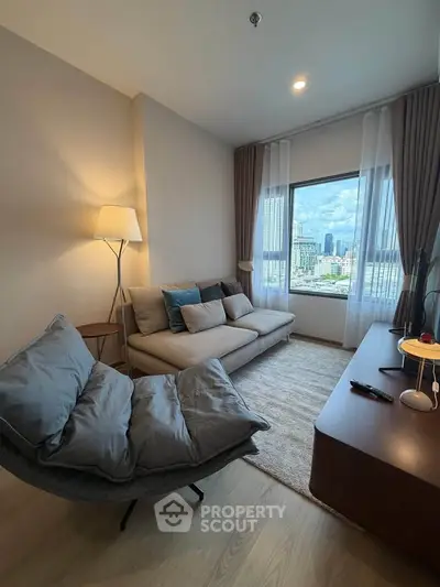 Modern living room with city view, cozy seating, and elegant decor in a high-rise apartment.