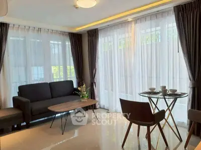 Elegant living room with modern furniture and large windows offering natural light.