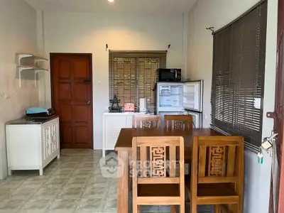 Charming kitchen with wooden dining set and open fridge, perfect for cozy family meals.