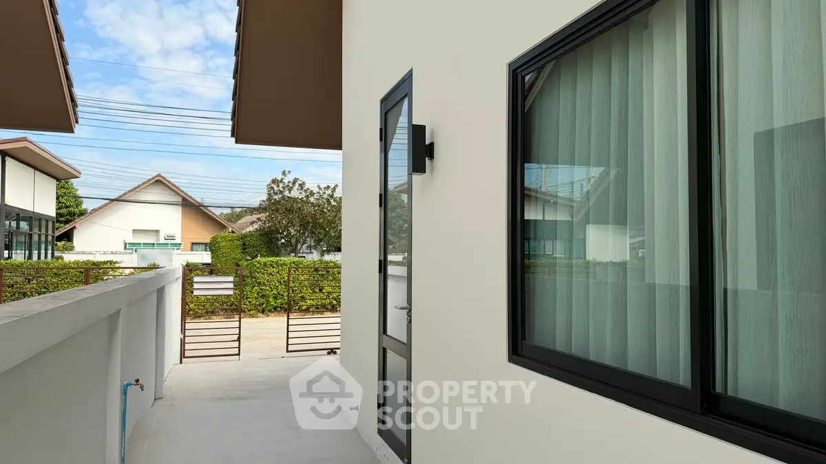 Modern residential exterior with sleek design and large windows, showcasing a contemporary home entrance.