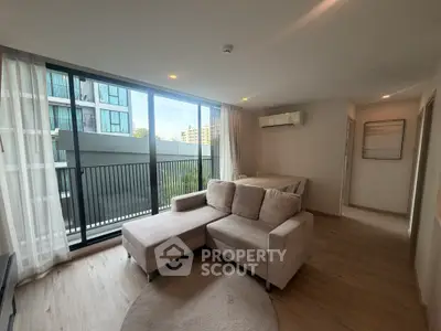 Modern living room with large windows and stylish furniture in a contemporary apartment.