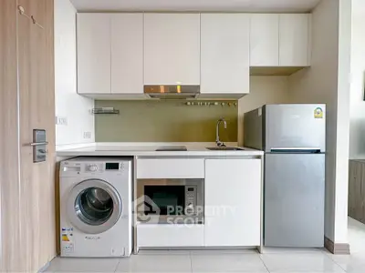 Modern kitchen with integrated appliances including washing machine and fridge