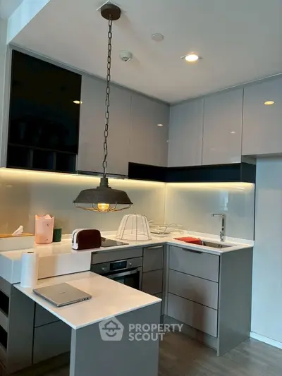 Modern kitchen with sleek cabinetry and stylish lighting in a contemporary apartment.