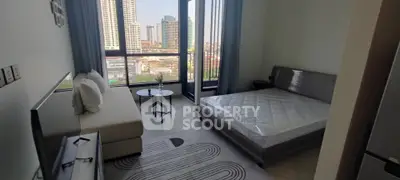 Modern bedroom with large windows and city view, featuring a cozy bed and stylish decor.