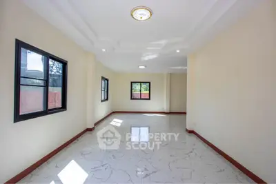 Spacious empty room with marble flooring and large windows for natural light