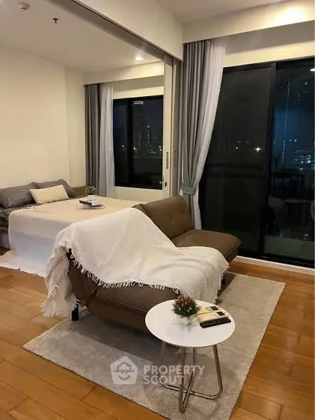 Cozy modern living room with city view, featuring stylish sofa and elegant decor.