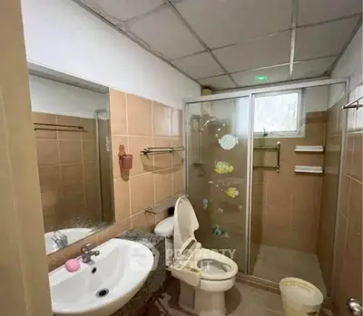 Cozy bathroom with shower enclosure and modern fixtures in a stylish real estate property.
