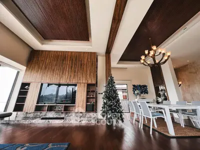 Luxurious living room with elegant dining area, wooden accents, and festive decor.