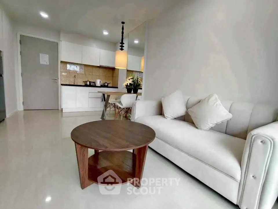 Modern open-layout living room with cozy sofa and stylish kitchen area.