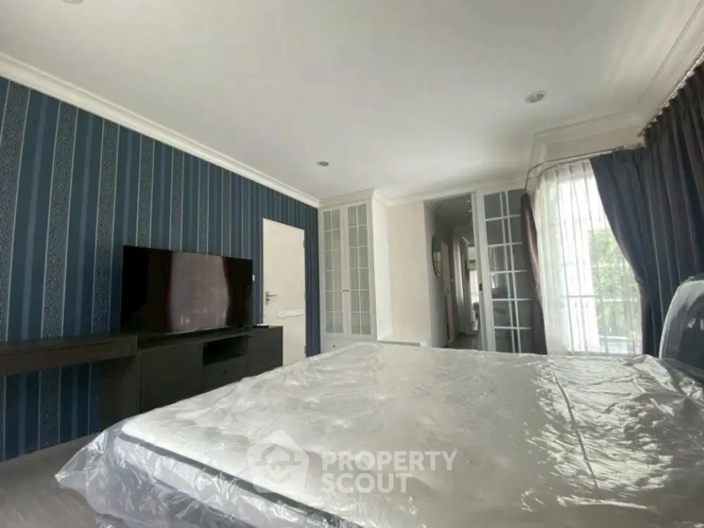 Spacious bedroom with modern decor and large windows for natural light