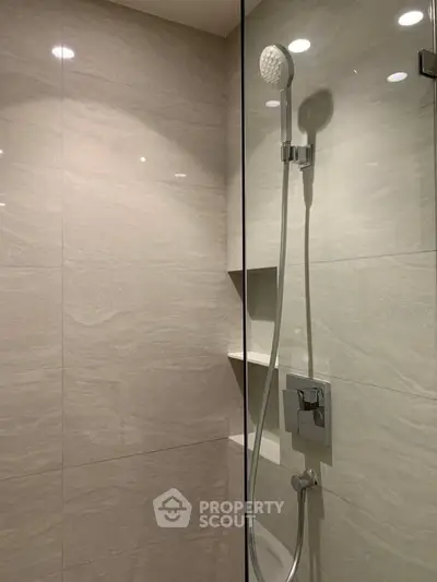 Modern bathroom shower with sleek tile design and built-in shelving
