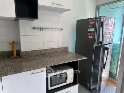 Modern kitchen with granite countertop and stainless steel fridge