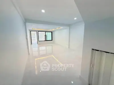 Spacious modern living room with sleek white tiles and large windows
