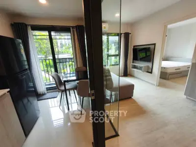 Modern apartment with open layout, featuring a cozy living room, dining area, and a view of the lush greenery outside.