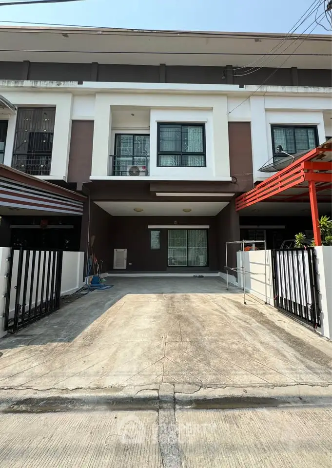 Modern townhouse exterior with driveway and gated entrance