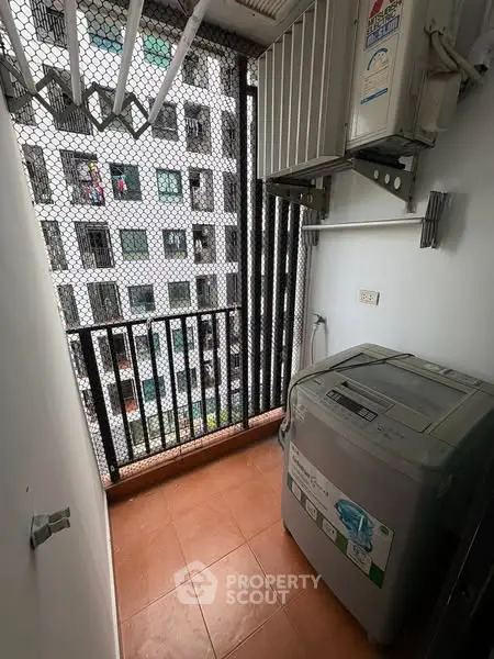 Compact balcony with washing machine and city view