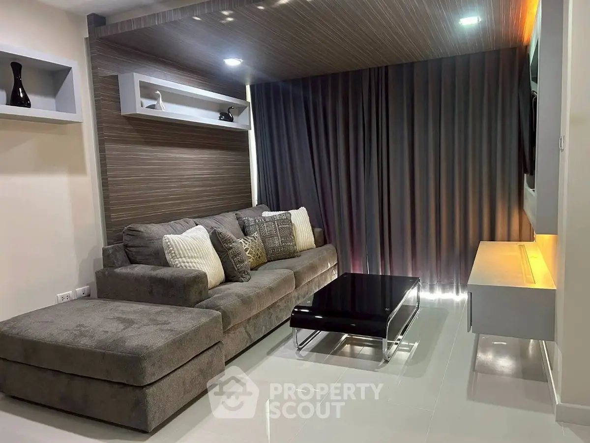Modern living room with stylish gray sectional sofa and sleek black coffee table.