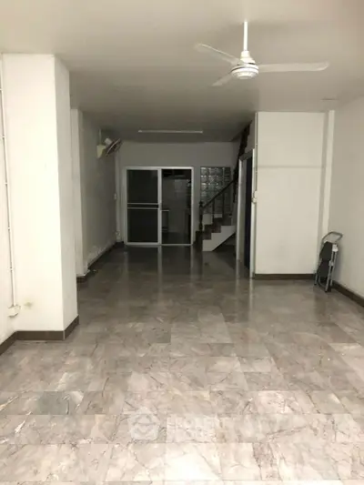 Spacious interior with marble flooring and ceiling fan, ideal for versatile use.
