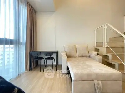 Modern living room with cozy beige sofa and sleek staircase