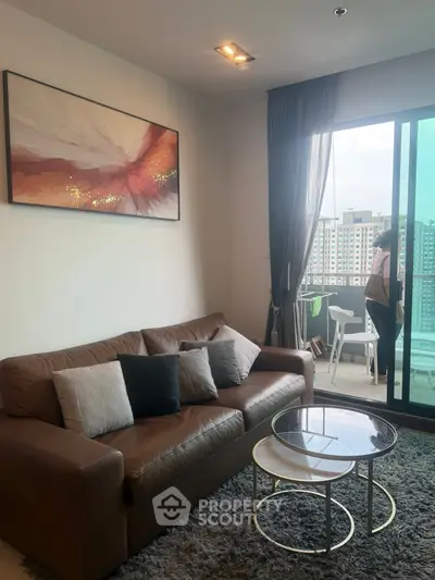 Modern living room with leather sofa and balcony view in high-rise apartment