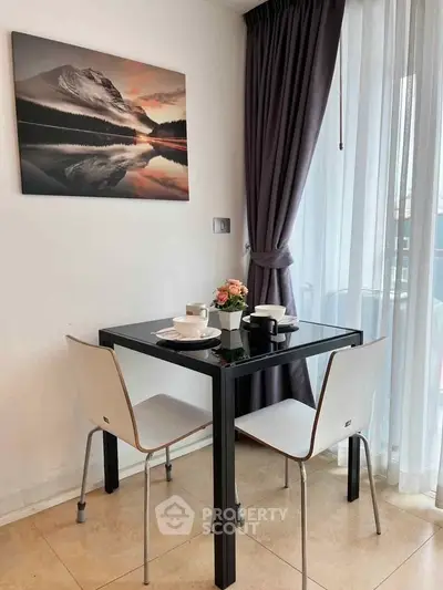 Cozy dining nook with modern table and chairs by a large window, perfect for intimate meals.