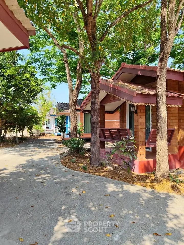 Charming wooden cabin surrounded by lush greenery and a serene pathway, perfect for a tranquil retreat.