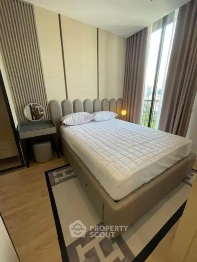 Modern bedroom with stylish decor and large window offering natural light.