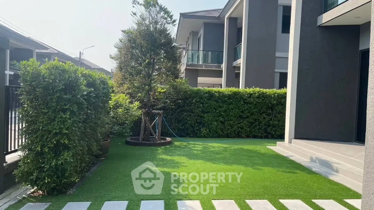 Modern home exterior with lush garden and artificial grass, perfect for outdoor relaxation.