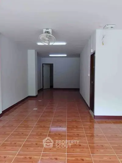 Spacious interior with wooden flooring and ceiling fan, ideal for customization.