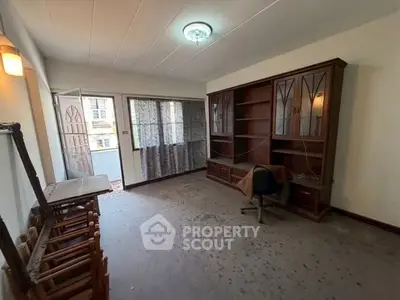 Spacious room with built-in wooden shelves and natural light, ideal for home office or study.