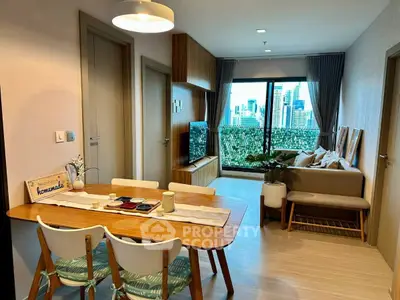 Modern living room with city view, stylish decor, and cozy dining area in a high-rise apartment.