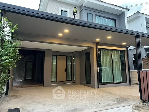 Modern two-story house with spacious carport and sleek exterior design.