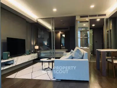 Modern living room with sleek design and open layout, featuring a cozy sofa and large TV.
