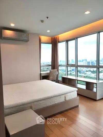 Spacious bedroom with panoramic city view and modern furnishings