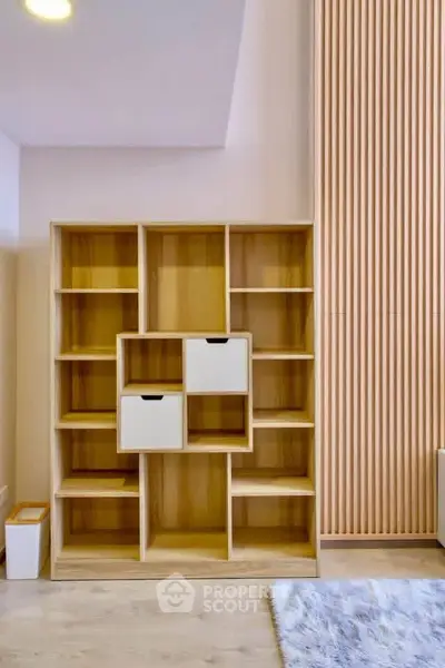 Modern wooden shelving unit in stylish living room interior