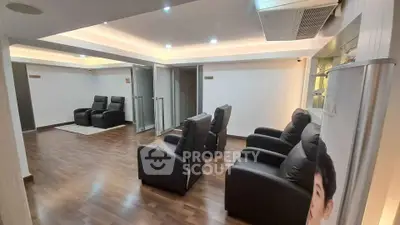 Spacious modern living area with sleek leather recliners and wooden flooring