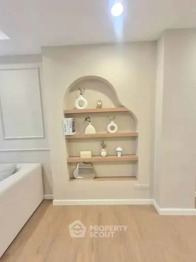 Modern living room with stylish built-in wall shelves and elegant decor accents.