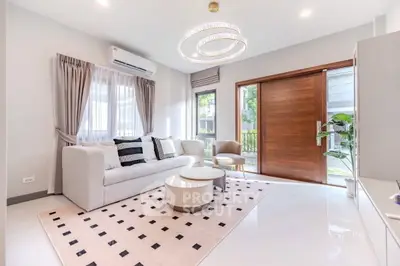 Elegant living room with modern decor, large windows, and stylish lighting in a cozy home.