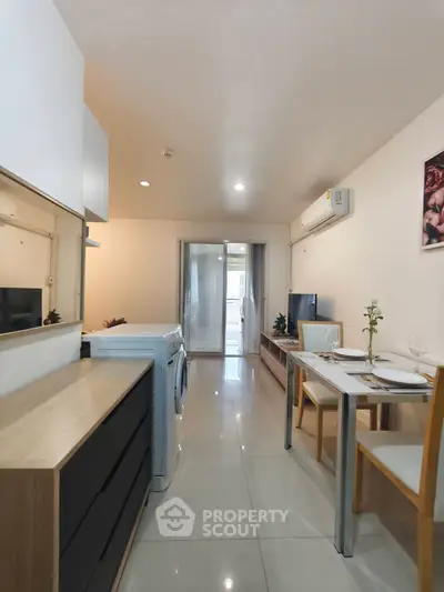 Modern apartment interior with sleek design, featuring a compact dining area and washing machine.