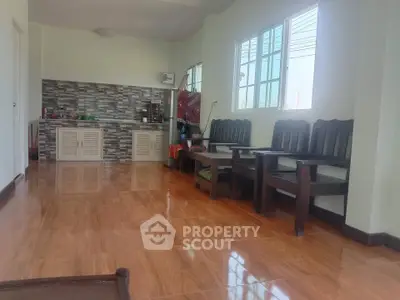 Spacious living area with wooden flooring and open kitchen layout